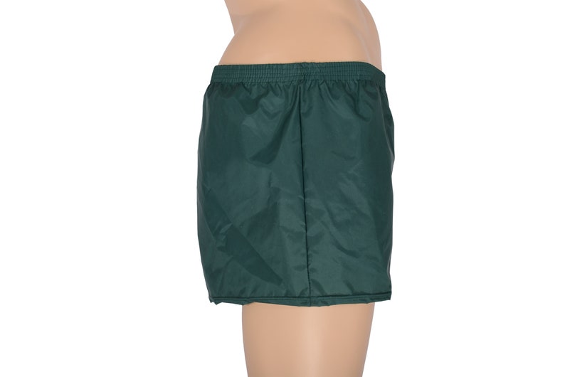 May include: Dark green nylon athletic shorts with an elastic waistband.
