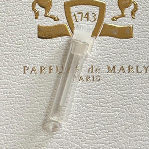 May include: A set of three ceramic mugs with a speckled, cream-colored glaze. Each mug features a different hand-painted floral design in shades of blue, green, and yellow. The mugs have a simple, rounded shape.