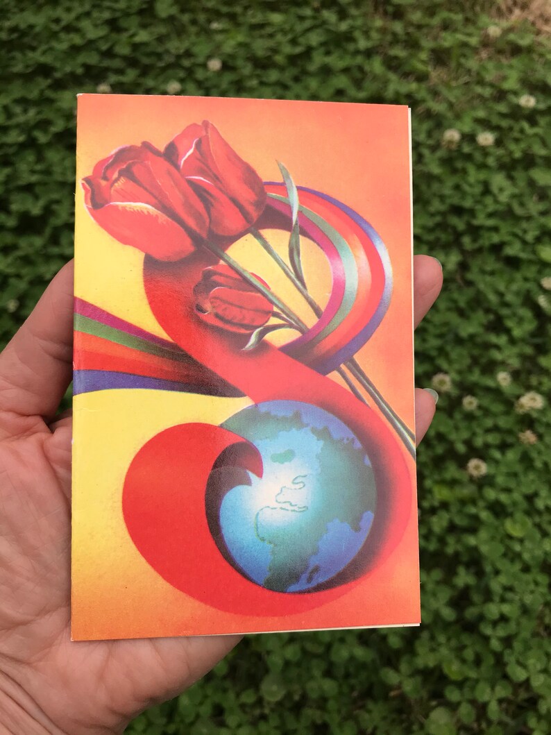 May include: A vintage postcard with a colorful design featuring a rainbow, a globe, and red tulips. The postcard has a yellow background with a red, orange, and yellow swirl.