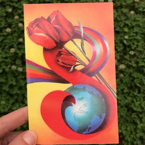 May include: A vintage postcard with a red, orange, and yellow background. A bouquet of red tulips is wrapped in a rainbow ribbon. A blue globe is in the lower right corner.