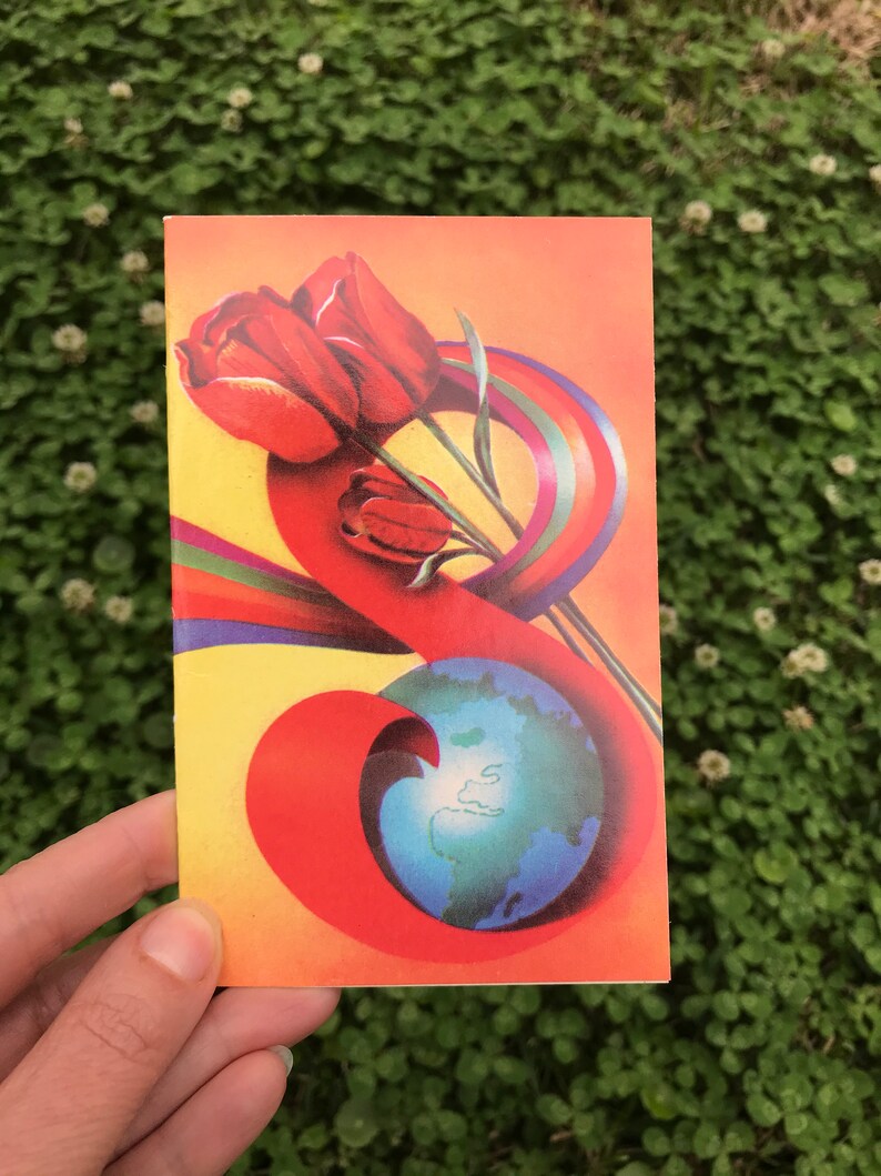May include: A vintage postcard with a colorful illustration of a globe surrounded by a rainbow and three red tulips.