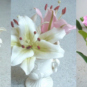 Op de afbeelding: Drie arrangementen van kunstbloemen in wit en roze. De eerste opstelling heeft twee roze lelies in een witte keramische vaas. De tweede opstelling heeft een witte lelie en een roze lelie in een witte keramische vaas. De derde opstelling heeft een cluster roze orchidee&euml;n in een zwarte pot.