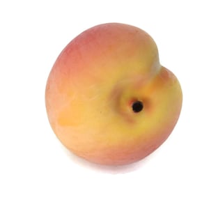May include: A single, ripe peach with a yellow and pink skin. The peach has a small, dark brown stem scar.