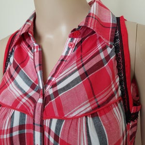 May include: Red and black plaid sleeveless shirt with a button-up collar and black lace trim on the straps.