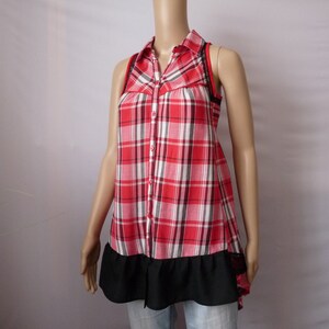 May include: A sleeveless red and white plaid shirt with a black ruffle trim and a black lace detail on the straps.