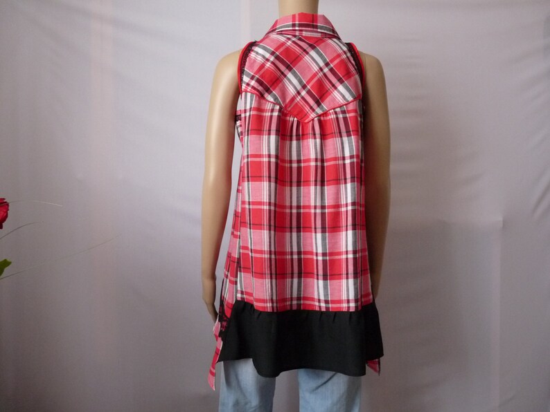 May include: A red and white plaid sleeveless shirt with a black trim and a ruffled hem.