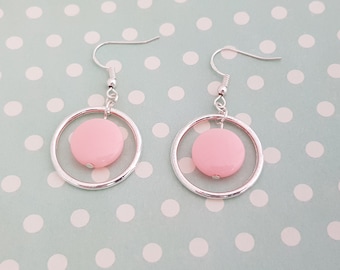 Lightweight silver hollow hoop earrings with pink acrylic coin beads, in a 60s mod style.