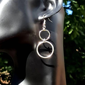 May include: Silver dangle earrings with two connected circles.