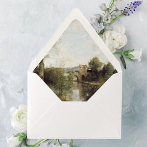 a lined envelope for a wedding invitation with a painting of a river