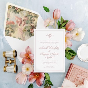 May include: A wedding invitation with pink and white flowers, a vintage book, and a pair of opera glasses. The invitation is for the wedding of Marielle Elizabeth and Benjamin Nicholas Lambert on Saturday, the sixth of June, at four o'clock in the afternoon at The Clifton, Charlottesville, Virginia.