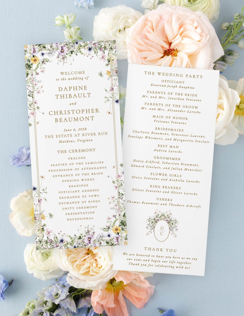 a wedding invitation card with a floral design, surrounded by white and pink flowers.