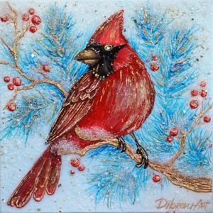 Puede incluir: Un pájaro cardenal rojo con cabeza negra y pico dorado posado en una rama de un pino azul con bayas rojas. El fondo es azul claro con nieve blanca.
