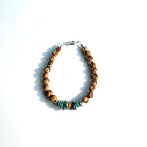 May include: A brown wooden bead bracelet with turquoise and orange accents.
