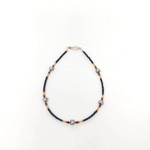 May include: A black beaded anklet with silver heart charms and red, yellow and white beads.