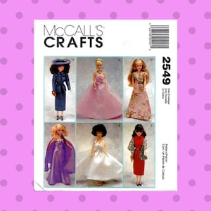 Pode incluir: Um envelope de padrão de costura McCall's Crafts com seis designs de bonecas. As bonecas estão vestidas com várias roupas, incluindo um fato azul, um vestido rosa e um vestido vermelho. O número do padrão é 2549.