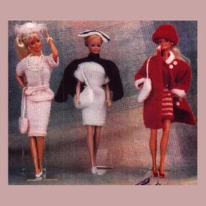 May include: Three Barbie dolls dressed in knitted outfits. The doll on the left wears a pink dress, hat, and purse. The middle doll is in a white dress with a black cape and purse. The doll on the right is in a red coat, hat, and purse.