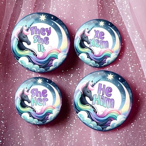 May include: Four round buttons with a unicorn and a crescent moon design. Each button has a different pronoun set: "They She It", "Xe Xem", "She Her", and "He Him".