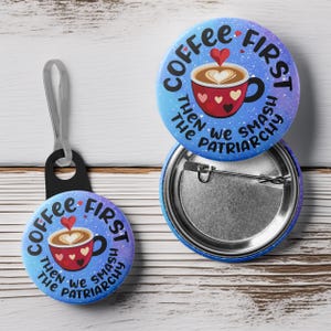 May include: Two blue and white button pins with a coffee cup and the text "Coffee First Then We Smash The Patriarchy".