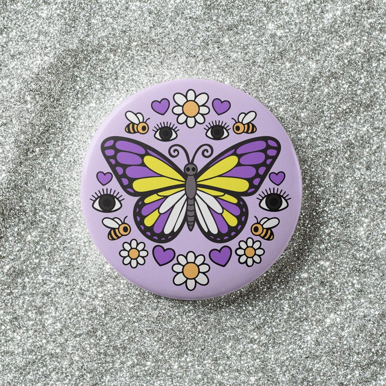 K&ouml;nnte beinhalten: Ein runder, lavendelfarbener Knopf mit einem Design aus Schmetterling, Bienen, Blumen, Herzen und Augen. Der Schmetterling hat lila und gelbe Fl&uuml;gel. Der Knopf ist ein dekoratives Accessoire.