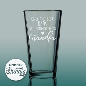 Może przedstawiać: Przezroczysty szklany kufel z białym napisem "ONLY THE BEST DADS GET PROMOTED TO Grandpa" ze symbolem serca. Na szkle w lewym dolnym rogu znajduje się logo Modern Shindig.
