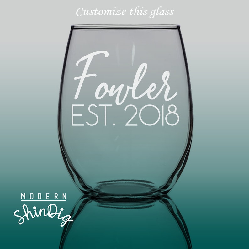 以下が含まれることがあります： 白い筆記体で「Fowler」と「EST. 2018」と書かれた透明なステムレスワイングラス。「Customize this glass」という言葉が上部にあります。Modern ShinDigのロゴが下部にあります。
