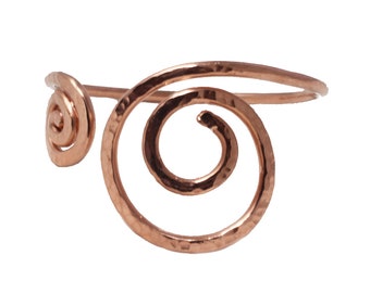 May include: A hammered copper bracelet with a spiral design. The bracelet is open and adjustable.