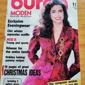 May include: A vintage magazine cover featuring a woman in a red paisley jacket. The magazine title is "Burda Moden Fashion Magazine" with text including "Exclusive Eveningwear" and "Christmas Ideas". The cover is dated November 1988.