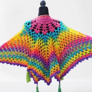 Puede incluir: Un chal de ganchillo arcoíris con un borde festoneado y borlas. El chal está hecho con una variedad de colores, incluyendo rojo, naranja, amarillo, verde, azul y morado.