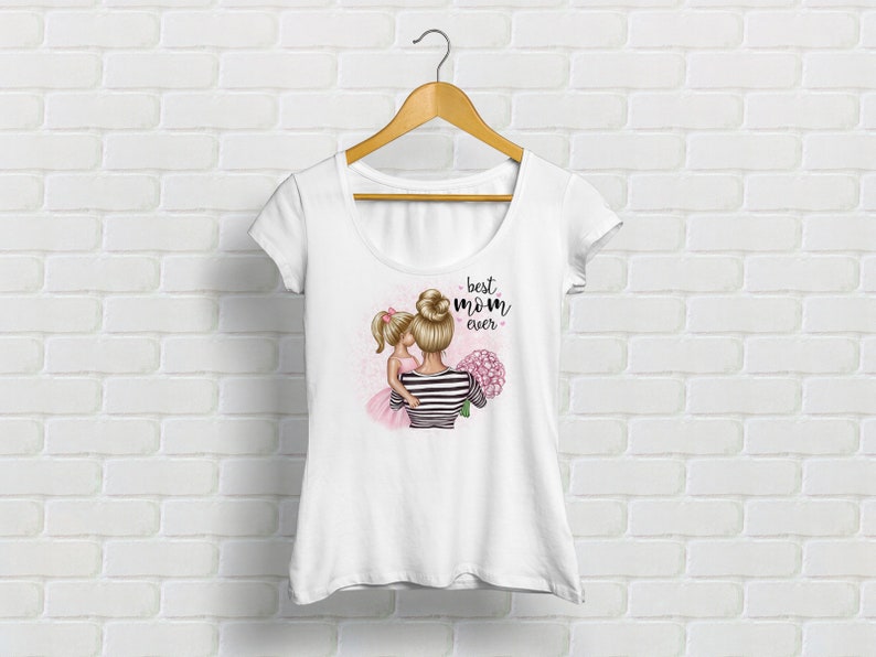 Puede incluir: Camiseta blanca con un gr&aacute;fico de una madre y una hija abraz&aacute;ndose. El texto "best mom ever" est&aacute; impreso en la camiseta.