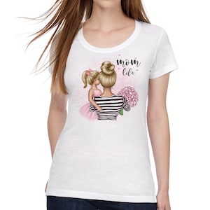 Puede incluir: Camiseta blanca con un gr&aacute;fico de una madre y una hija sosteniendo flores rosas. El texto "mom life" est&aacute; impreso en la camiseta.