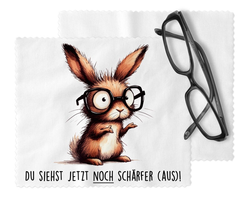 K&ouml;nnte beinhalten: Ein wei&szlig;es Mikrofaser-Reinigungstuch mit einem Comic-Hasen, der eine Brille tr&auml;gt und den Text "DU SIEHST JETZT NOCH SCH&Auml;RFER (AUS)!".