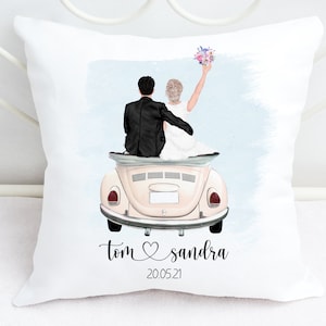 May include: White square cushion featuring a custom illustration of a newlywed couple in a vintage car. The bride holds a bouquet. The names "Tom & Sandra" and the date "20.05.21" are printed below.