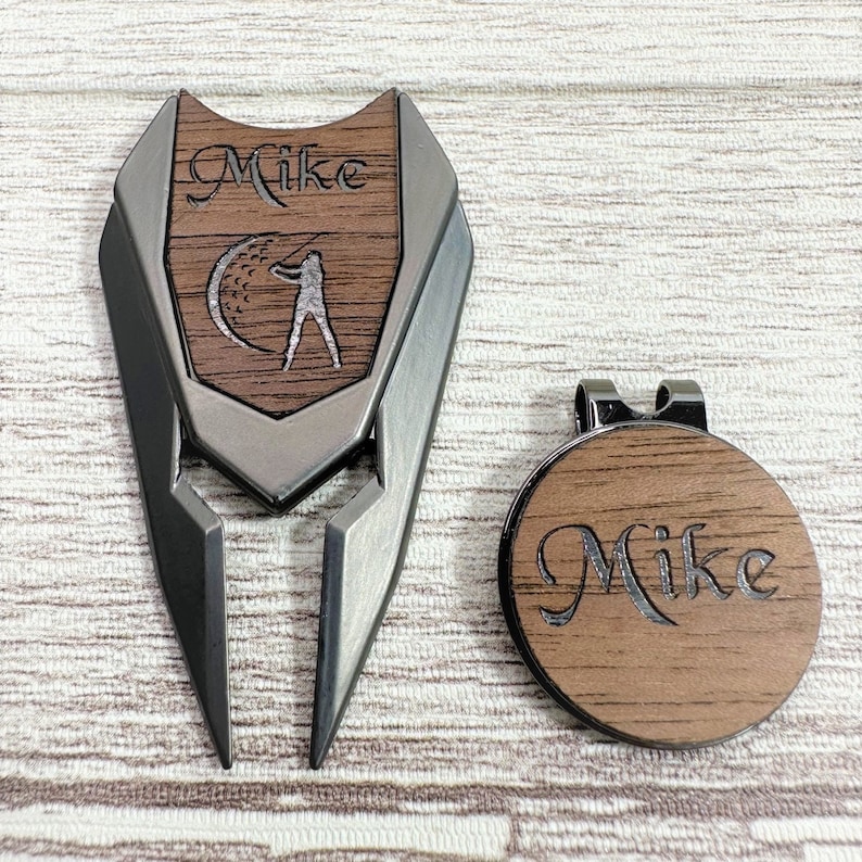 Pu&ograve; includere: Un set personalizzato di marcatore per palline da golf e strumento per riparare i divot con il nome "Mike" inciso su entrambi i pezzi. Lo strumento per riparare i divot &egrave; in metallo e ha una finitura nera. Il marcatore per palline &egrave; in legno e ha una finitura marrone.