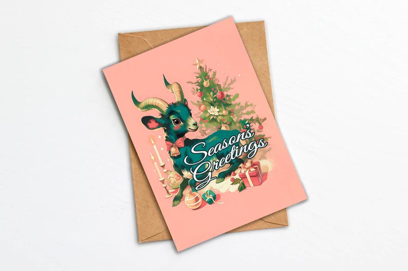 May include: A pink Christmas card with a green goat wearing a red bow and a Christmas tree in the background. The text on the card reads "Seasons Greetings".