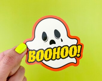 May include: A white ghost sticker with a sad face and the word "BOOHOO!" in yellow letters on a red background.