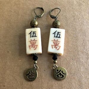 May include: A set of three ceramic mugs with a speckled, matte finish. The mugs are in shades of cream, light gray, and dark gray. Each mug has a simple, minimalist design and a rounded handle.