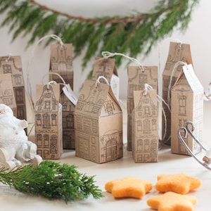 Könnte beinhalten: Ein Set aus 8 kleinen braunen Papierboxen in Form von Häusern mit weißen Umrissen und schwarzen Details. Die Boxen sind mit einer Schnur aufgehängt und mit einer Weihnachtsmann-Figur in einem Schlitten und einem Schaukelpferd verziert.