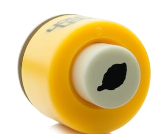 May include: Yellow plastic craft punch with a white die that cuts out a lemon shape. The die has a black lemon silhouette.