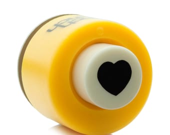 May include: Yellow heart-shaped paper punch with a white die and a black heart design.