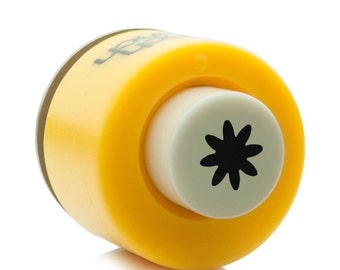 May include: Yellow and white plastic punch with a black flower design. The punch is used to create paper crafts.