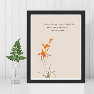 May include: A framed print with a beige background featuring a watercolor painting of orange flowers and green leaves. The print includes the text "Tension is who you think you should be. Relaxation is who you are. Chinese Proverb."