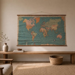 May include: A vintage-style world map wall hanging featuring a teal ocean background and muted earth-toned continents. The map is mounted on two horizontal wooden rods with a string for hanging and includes Greek text at the top border.