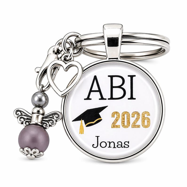 Pu&ograve; includere: Un portachiavi argentato con un ciondolo rotondo con la scritta "ABI 2026" e un cappello di laurea. Il portachiavi include un ciondolo a forma di cuore, un ciondolo a forma di angelo con una perla viola e il nome "Jonas".