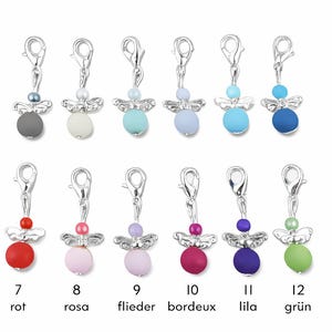 Pu&ograve; includere: Una collezione di dodici ciondoli a forma di angelo in vari colori, ciascuno con un fermaglio e ali argentate. I ciondoli presentano un corpo di perline colorate e una testa di perline pi&ugrave; piccola. I colori includono grigio, bianco, blu, rosso, rosa, viola e verde.