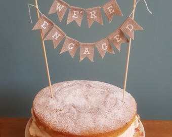 Hessian Cake Topper Bunting 'NOUS SOMMES ENGAGÉS'. Décoration de gâteau simple et douce.