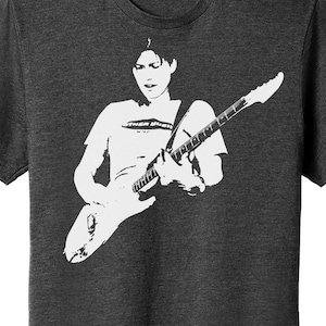 Può includere: Una silhouette in bianco e nero di una persona che suona una chitarra elettrica. La persona indossa una maglietta con il testo "Other Music NYC" sopra.