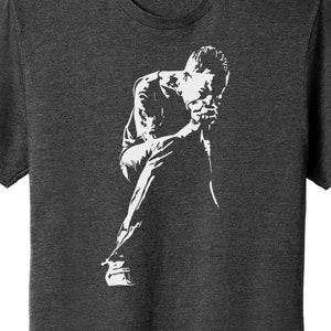 May include: A white silhouette of a person sitting with their head in their hands on a dark gray t-shirt.