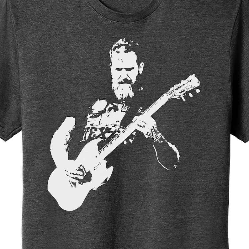 May include: A black and white silhouette of a person playing a guitar. The person has a beard and is wearing a shirt with a pattern. The guitar is a solid white silhouette.
