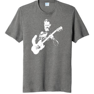 May include: A heather grey t-shirt with a white silhouette of a man playing a guitar.