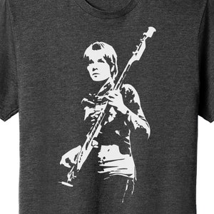 May include: A white silhouette of a person playing a bass guitar on a dark heather grey t-shirt.
